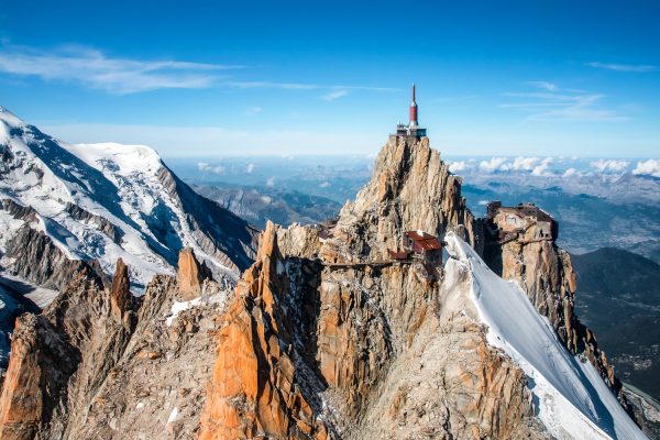Beautiful landscape aerial view from helicopter of Aiguille du Midi summit from Mont Blanc massif in french Alps mountains in autumn season during a sunny day, with clear sky. Taken in Haute-Savoie, Auvergne-Rhone-Alpes region in France (Europe).